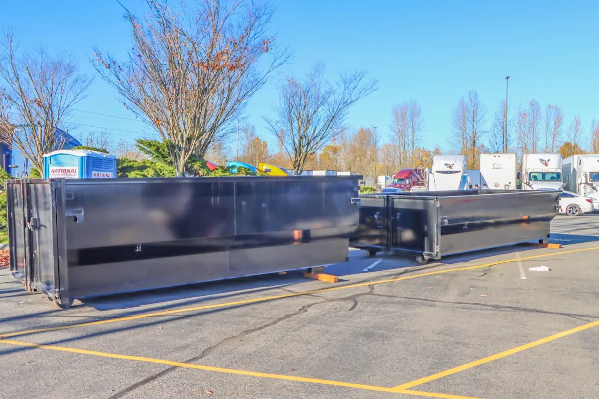 Professional dumpster rental service with roll-off container on residential driveway in Pompey